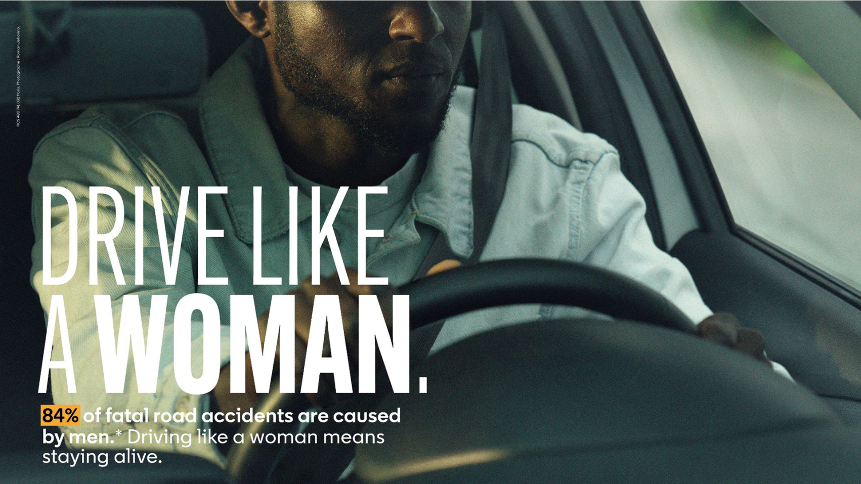 The image features a man driving with a serious expression, accompanied by text that reads "DRIVE LIKE A WOMAN" and emphasizes that "84% of fatal road accidents are caused by men," promoting safer driving habits.