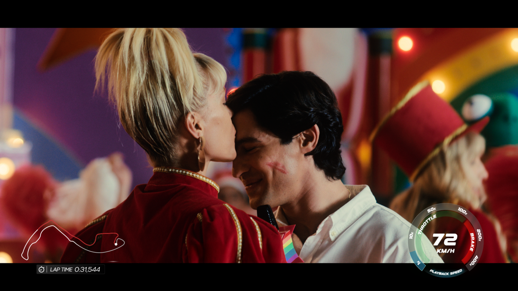 The image captures a tender moment between a couple in a colorful, festive setting, with the woman playfully kissing the man's forehead, who has a lipstick mark on his cheek, showcasing a joyful and romantic atmosphere.