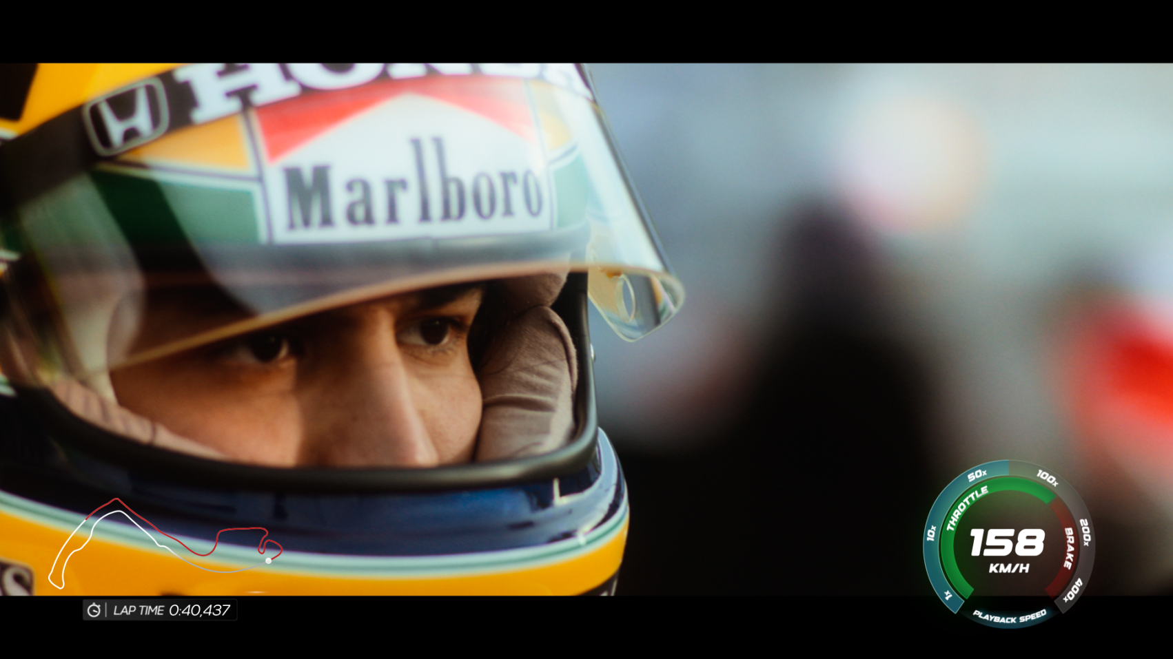 The image features a close-up of a race car driver wearing a helmet adorned with sponsor logos, focusing intently, with the background blurred to emphasize his expression and the speed meter indicating 158 km/h.
