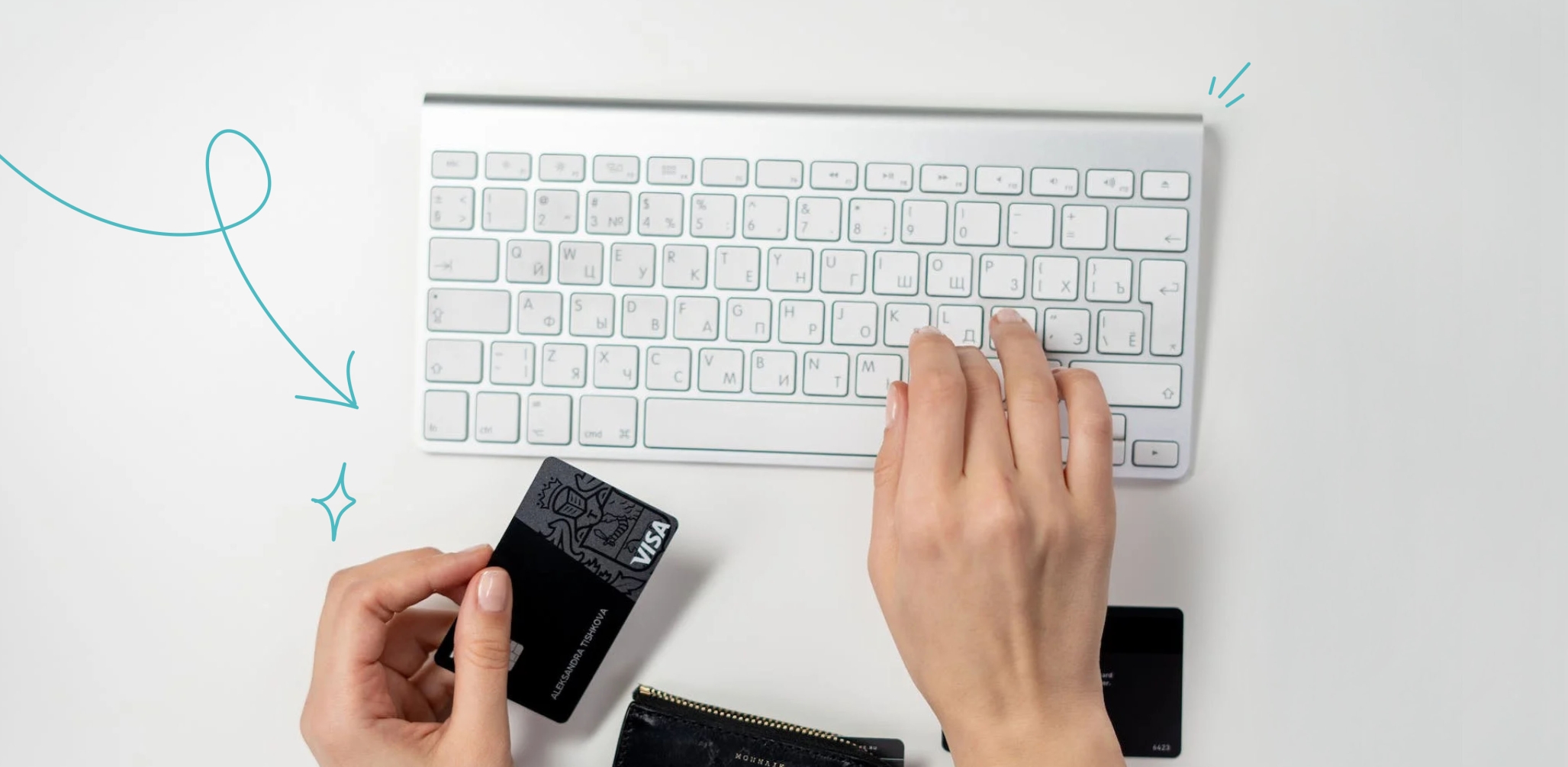 A person's hands on a keyboard holding a credit card