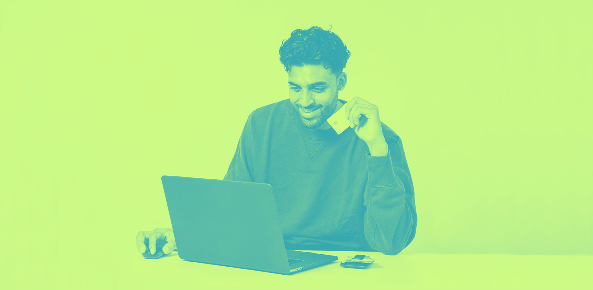 A person on their laptop ordering something holding a credit card