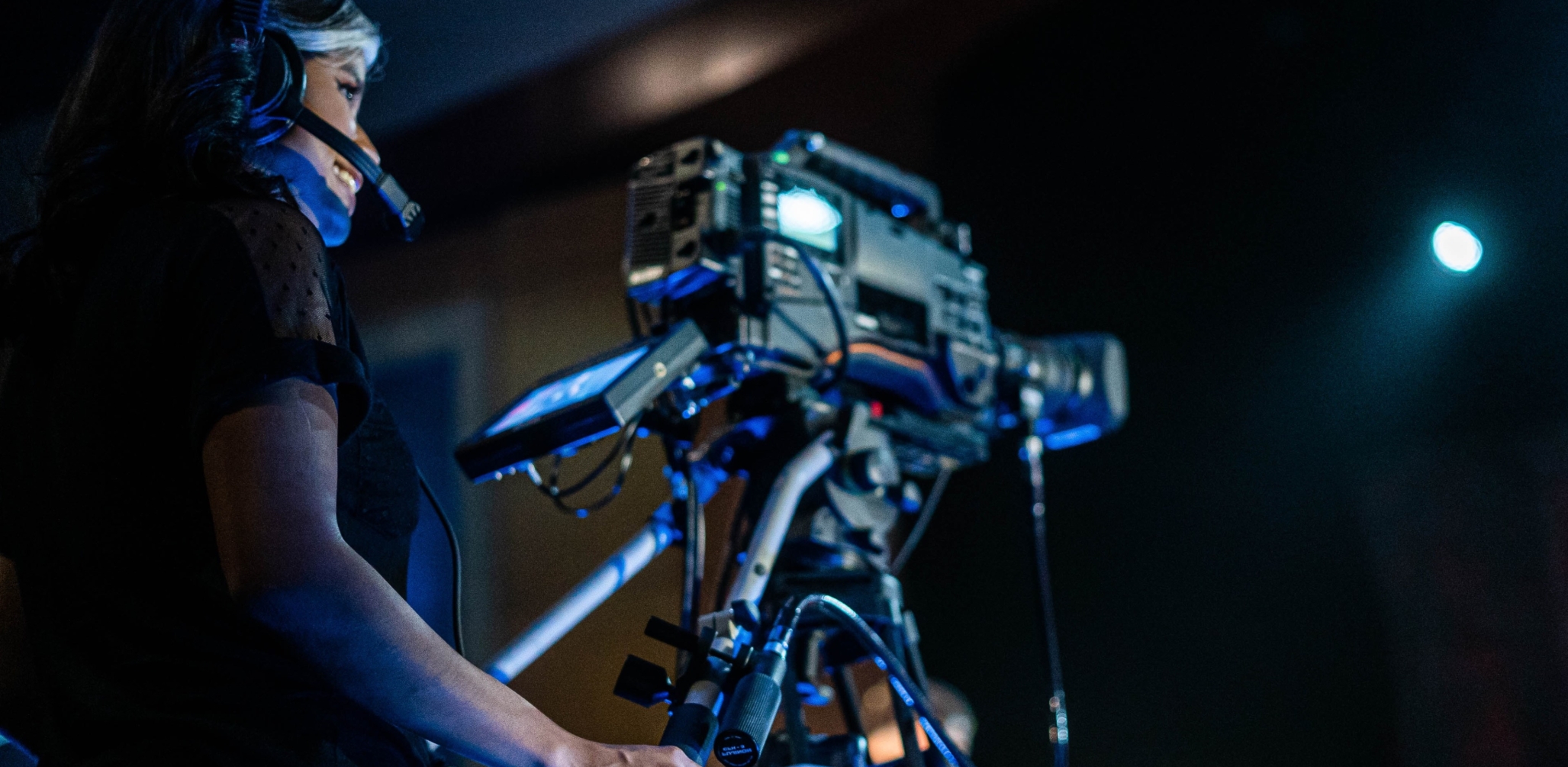 Image that features woman behind a filming camera