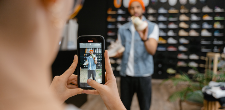person photographing someone trying clothes on at a store