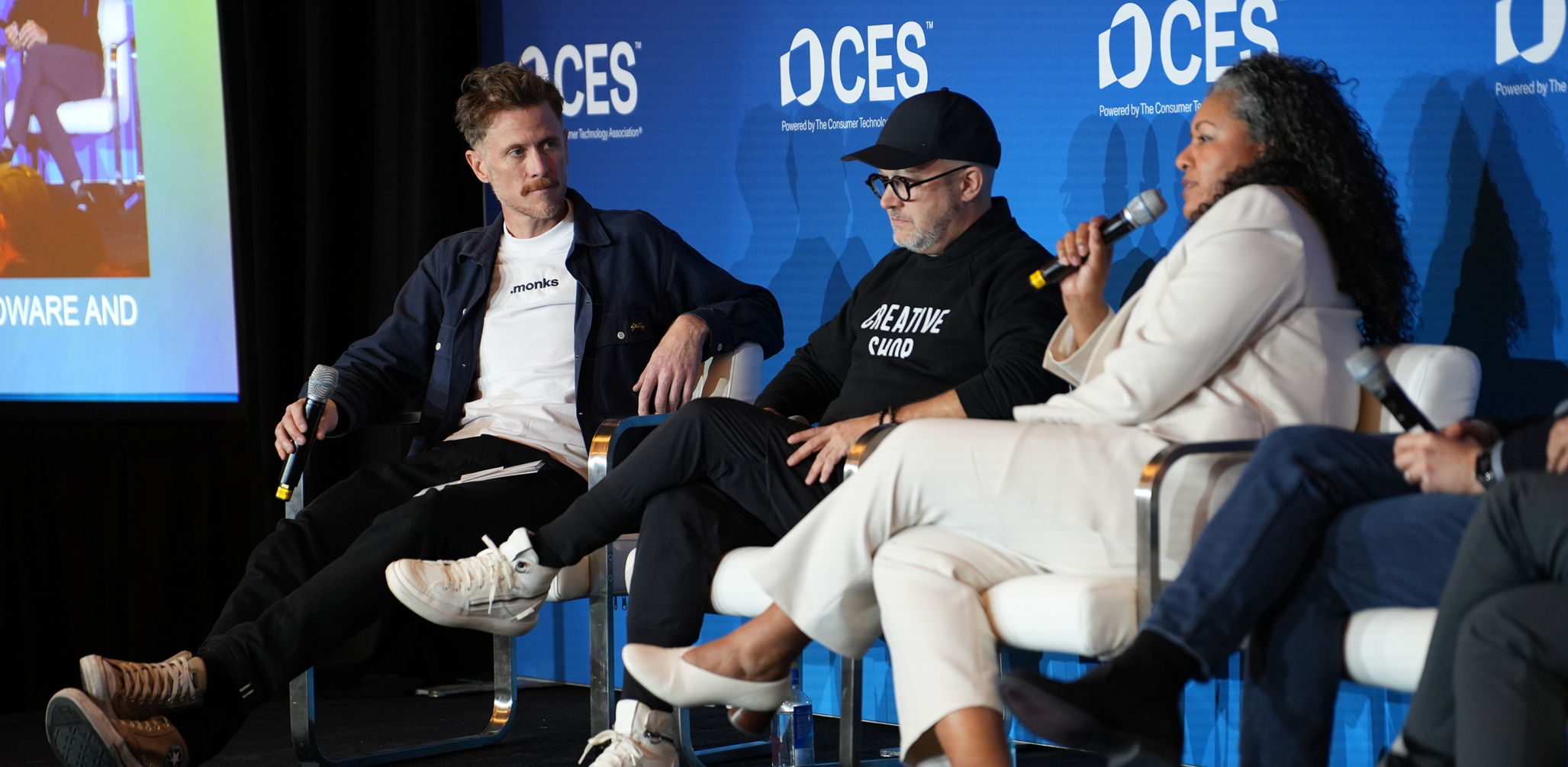 three people sitting on a stage at CES