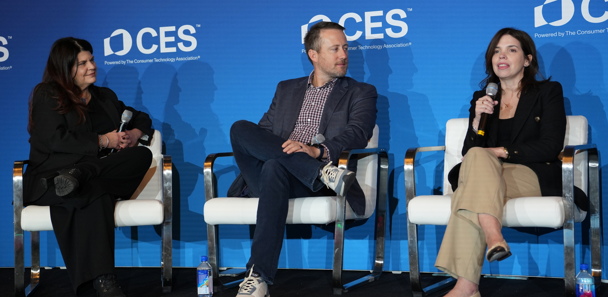 three people sitting on a stage at CES
