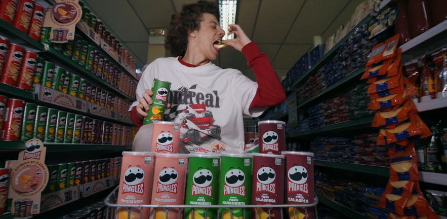 white man with long hair eating pringles snacks