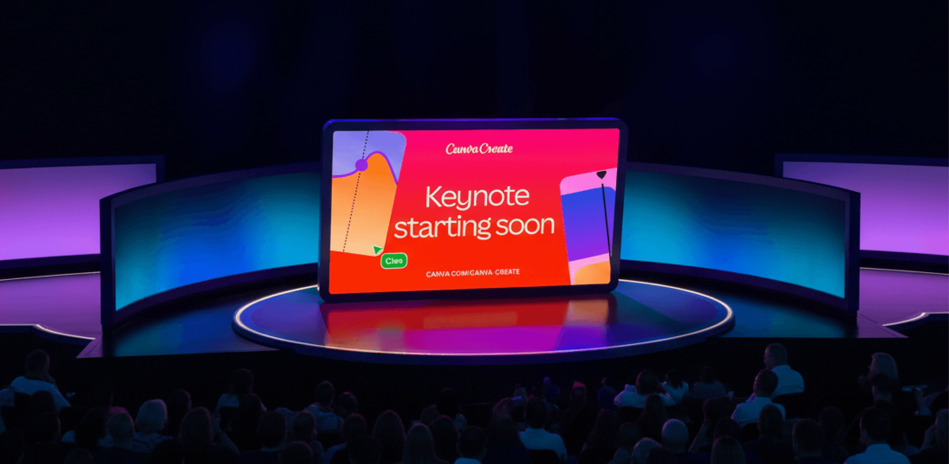 A wide shot of a tech conference stage featuring a large, tablet-shaped central screen that reads "Canva Create" and "Keynote starting soon." The screen is bright red, flanked by curved, glowing blue side panels. In the foreground, a large audience is seated in a darkened theater setting, facing the stage.