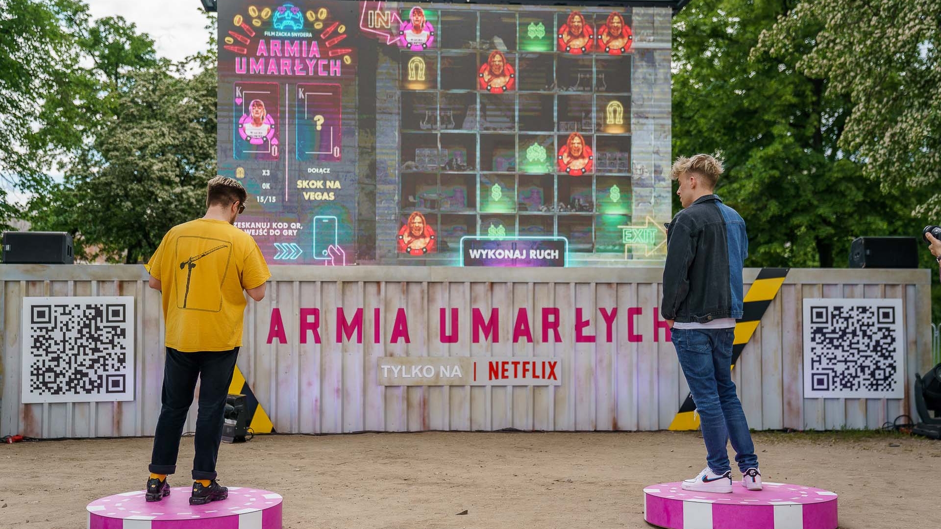 An event booth with two people standing on casino chips playing a game