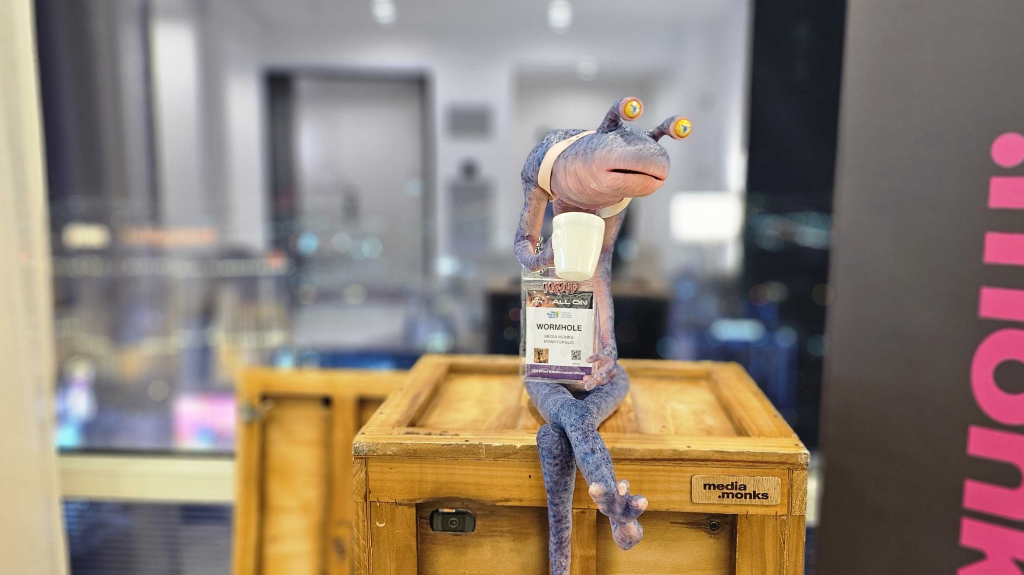 An animatronic in the form of an alien sits atop a crate.