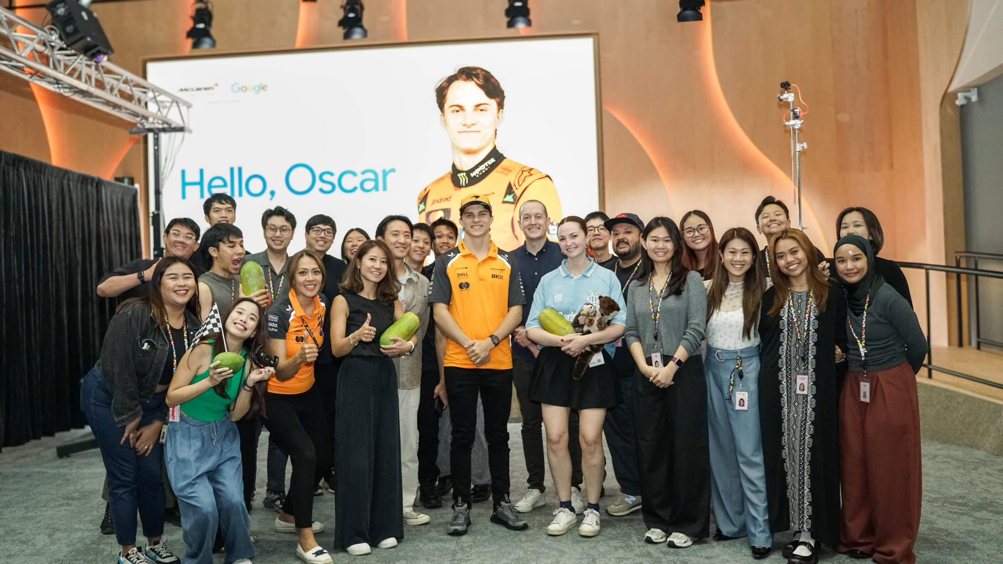 Oscar Piastri F1 driver standing with the Google team and Singapore Monks.