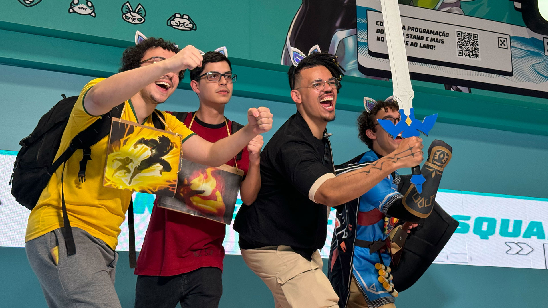 Four people pose in an engaging pose. One person is holding a sword.