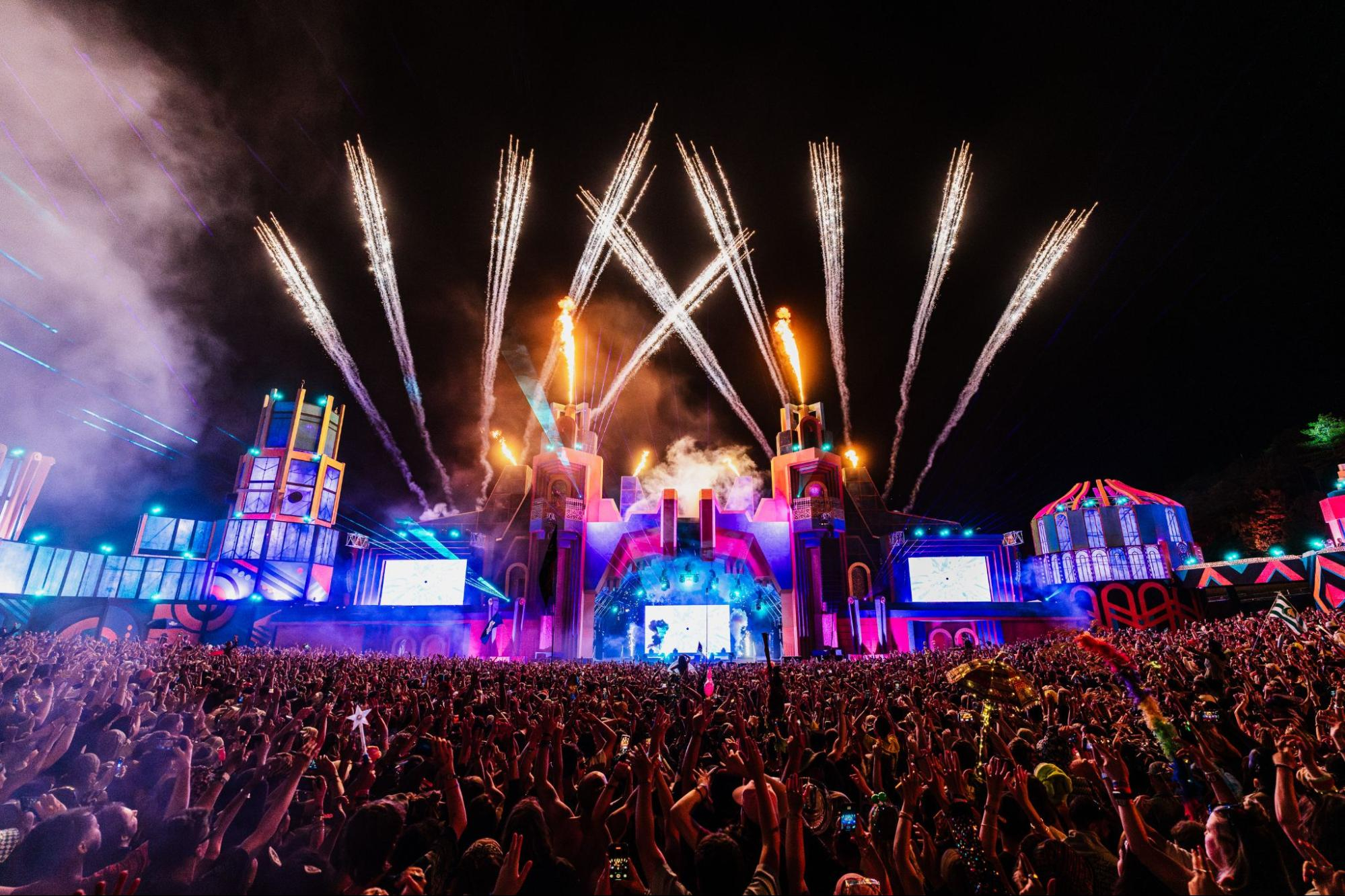 The full scope of the Monks AI-platform experience at Boomtown, showcasing the interactive stage design and synchronized light show, as seen by a large festival crowd.