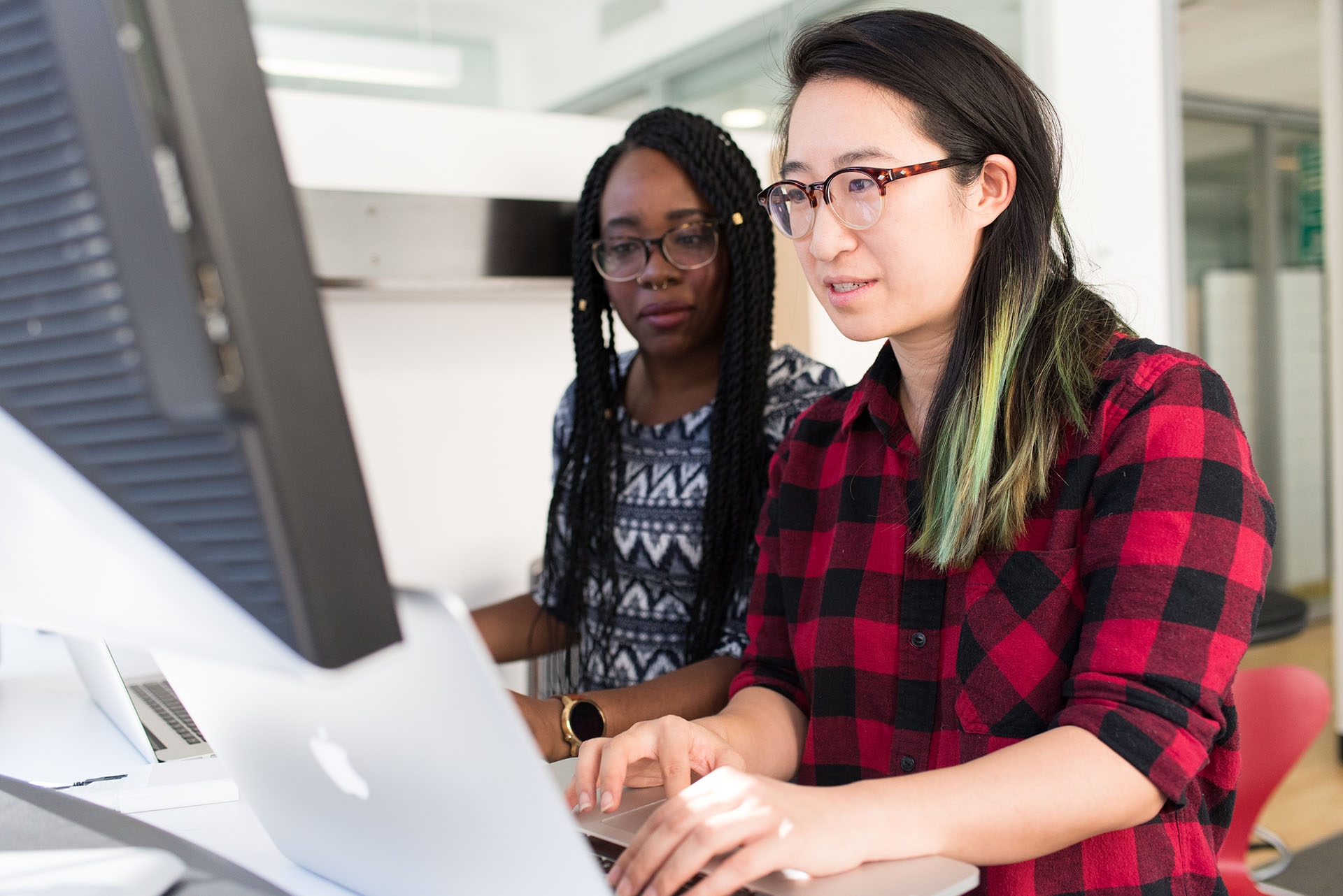 Two employees working on a desktop together