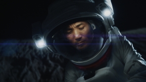 A person in a space suite floating in a dark space