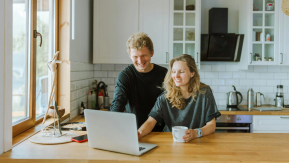 People looking at laptop in kitchen