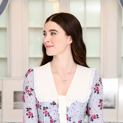 A woman in a dress in front of a large window