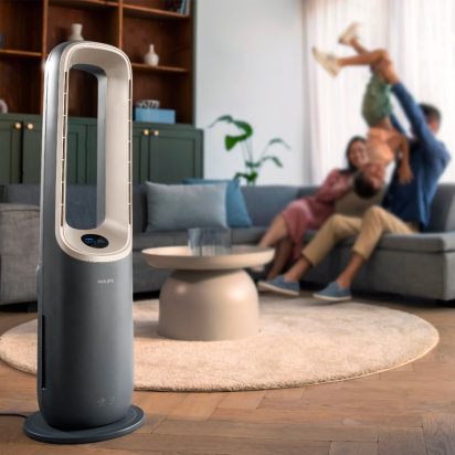 A family having fun in a living room with a phillips fan on display