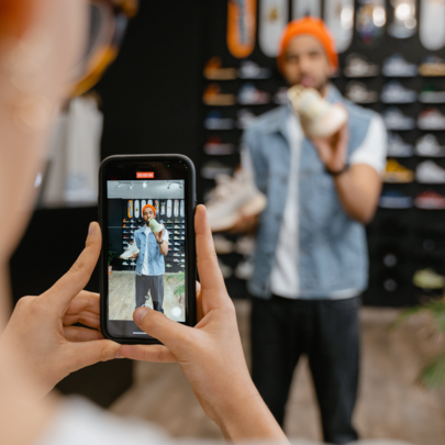 person photographing someone trying clothes on at a store