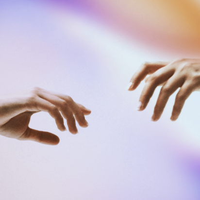 Two hands reaching towards each other with fingers slightly extended, set against a soft, gradient background of purple, blue, and orange hues. One hand has a black wristband.