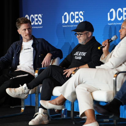 three people sitting on a stage at CES