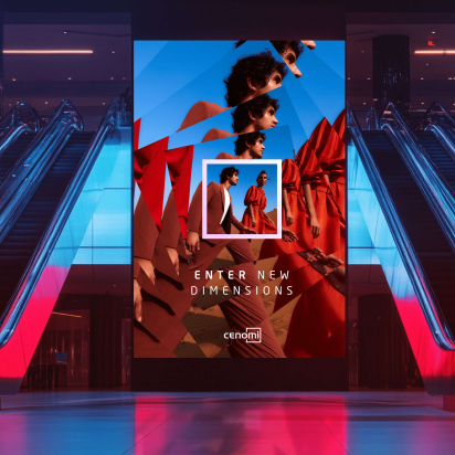 An advertising screen in a transit hub or mall; it is flanked by escalators on each side. The screen reads "Enter new dimensions - Cenomi" and depicts a fashionably dressed man and woman walking in a desert.