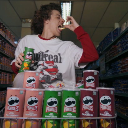 white man with long hair eating pringles snacks