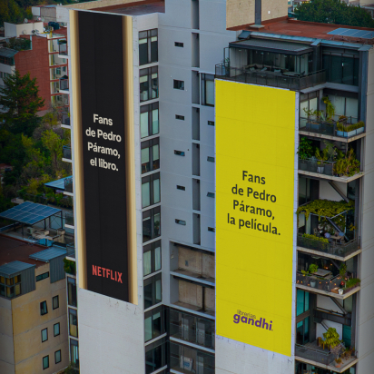 The image features two large billboards on buildings, one advertising a book titled "Pedro Páramo" associated with Netflix, and the other promoting the film adaptation of the same title.