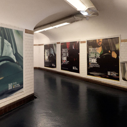 The image depicts an underground passage lined with posters promoting safe driving, using the slogan "CONDUISEZ COMME UNE FEMME," while statistics indicate that 84% of road fatalities involve men.