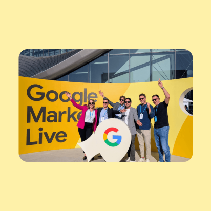 A group photo of Monks standing in front of a banner that reads "Google Marketing Live."