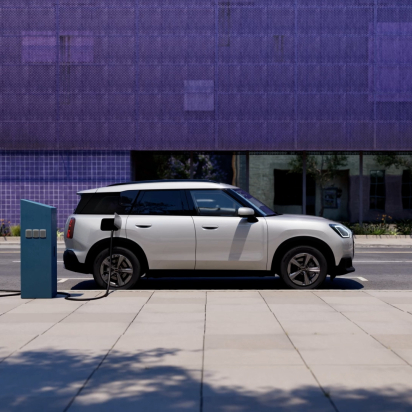 A mini cooper electric charging on the street