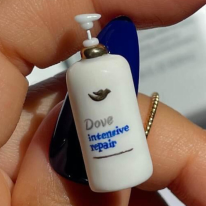 A hand-made miniature Dove Hair product affixed to the blue thumbnail of an influencer.