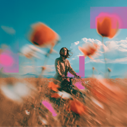 Girl standing in a flower field with a bicycle 