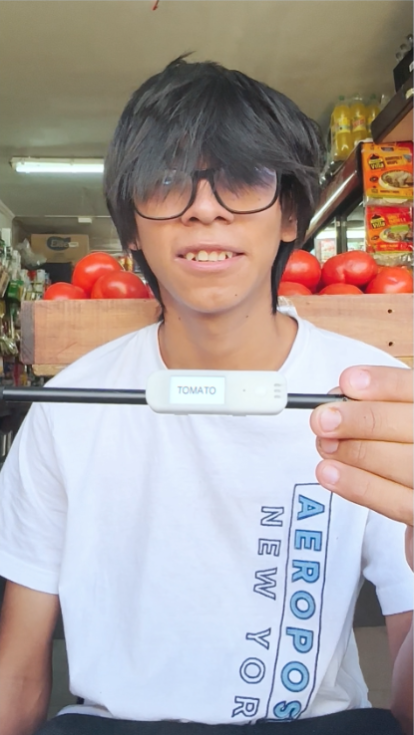 A boy holding the Literacy Pen smiling