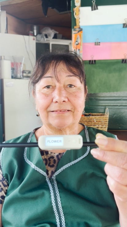 A woman holding the Literacy Pen smiling