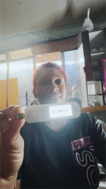 A woman holding the Literacy Pen smiling