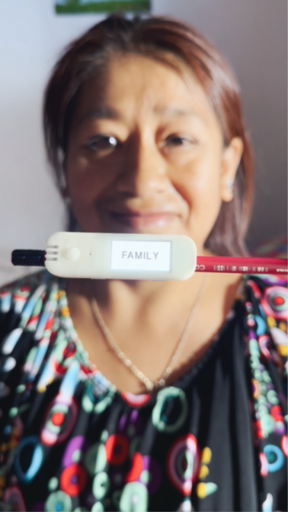A woman holding the Literacy Pen smiling