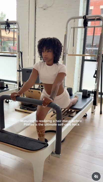 A woman stretching for pilates while recommending Dove Hair products to her followers.