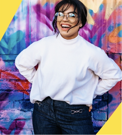 A person smiling in front of a colorful wall