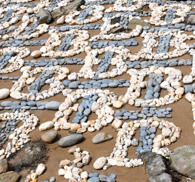 Rocks on a beach making up the Burberry Monogram