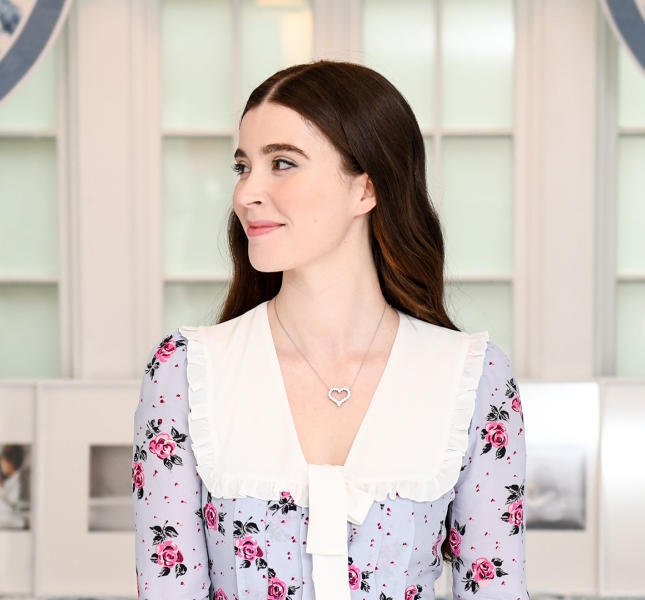 A woman in a dress in front of a large window