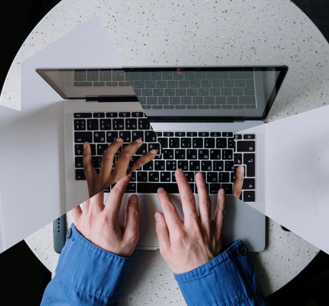 Two hands typing on a laptop
