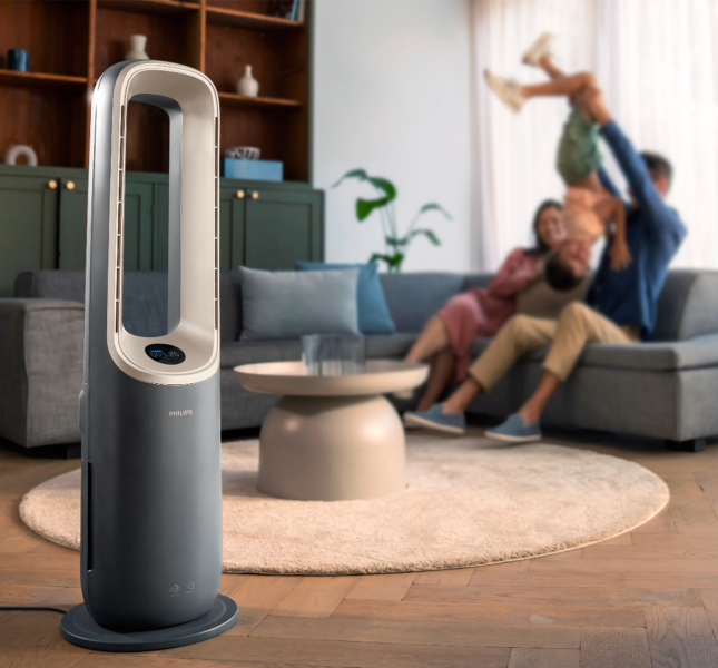 A family having fun in a living room with a phillips fan on display