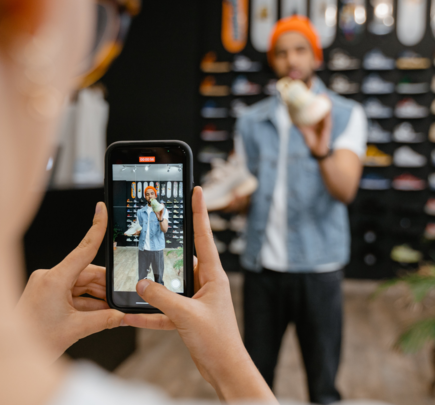 person photographing someone trying clothes on at a store
