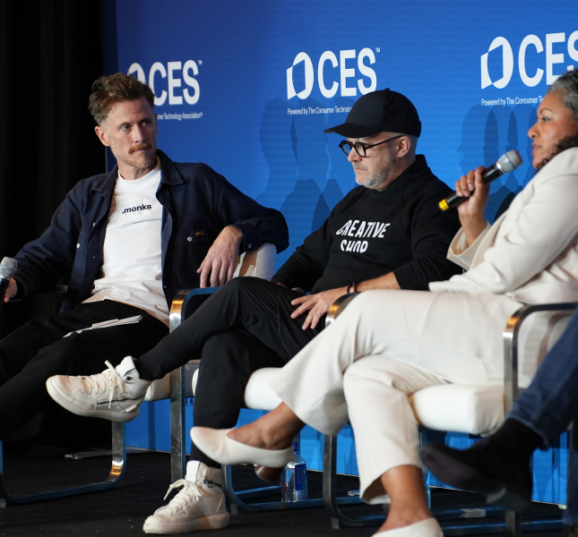 three people sitting on a stage at CES