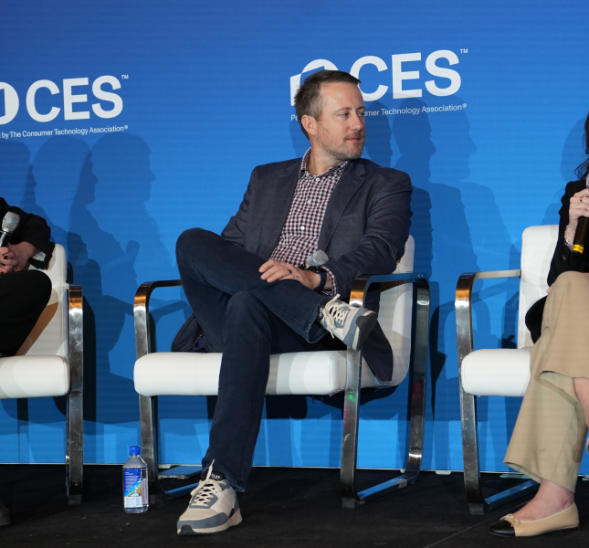 three people sitting on a stage at CES