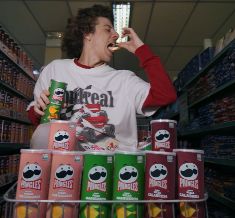 white man with long hair eating pringles snacks