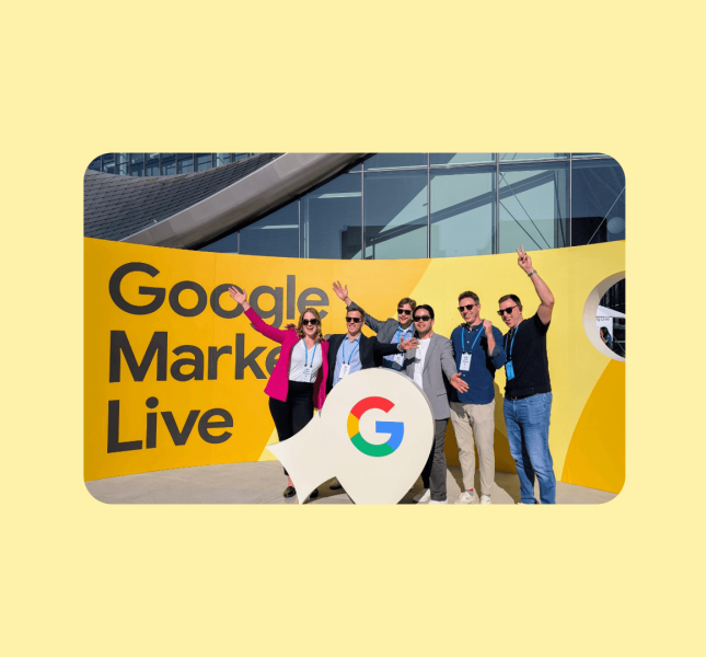 A group photo of Monks standing in front of a banner that reads "Google Marketing Live."