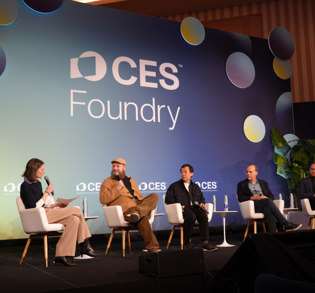 a panel of people on a stage with a sign that reads "CES"