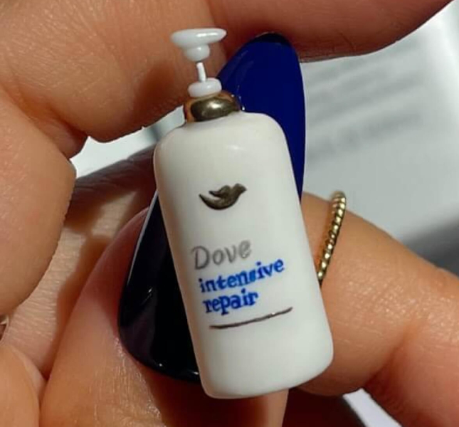 A hand-made miniature Dove Hair product affixed to the blue thumbnail of an influencer.