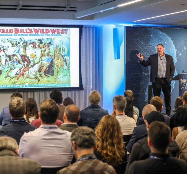 A presenter from the IAB Tech Lab showing a vintage advertisement to a room full of marketing industry leaders.